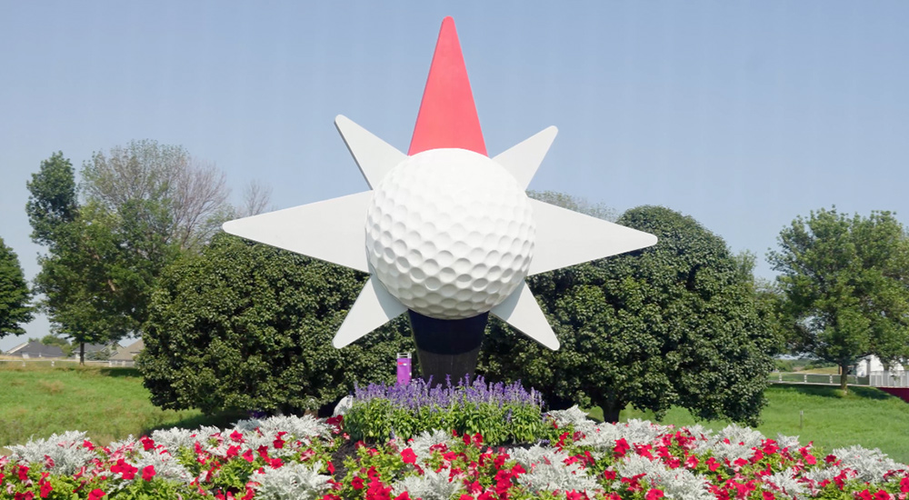 large golf ball display over a bed of flowers