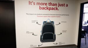 Vinyl graphic installed on wall that reads "It's more than just a backpack," reflecting the values of Kids in Need Foundation. Wall graphic installed by Brand ink.
