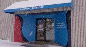 The colorful exterior of the entrance to the Kids in Need Foundation headquarters was brought to life by Brand Ink's installation of several colorful architectural graphics placed on the wall beside a glass door, on-door decals, and the awning above the entrance.