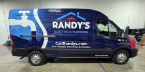 A newly wrapped Ford Transit advertising Randy's Electric & Plumbing waits in the installation bay at Brand ink