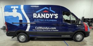 A newly wrapped Ford Transit advertising Randy's Electric & Plumbing waits in the installation bay at Brand ink