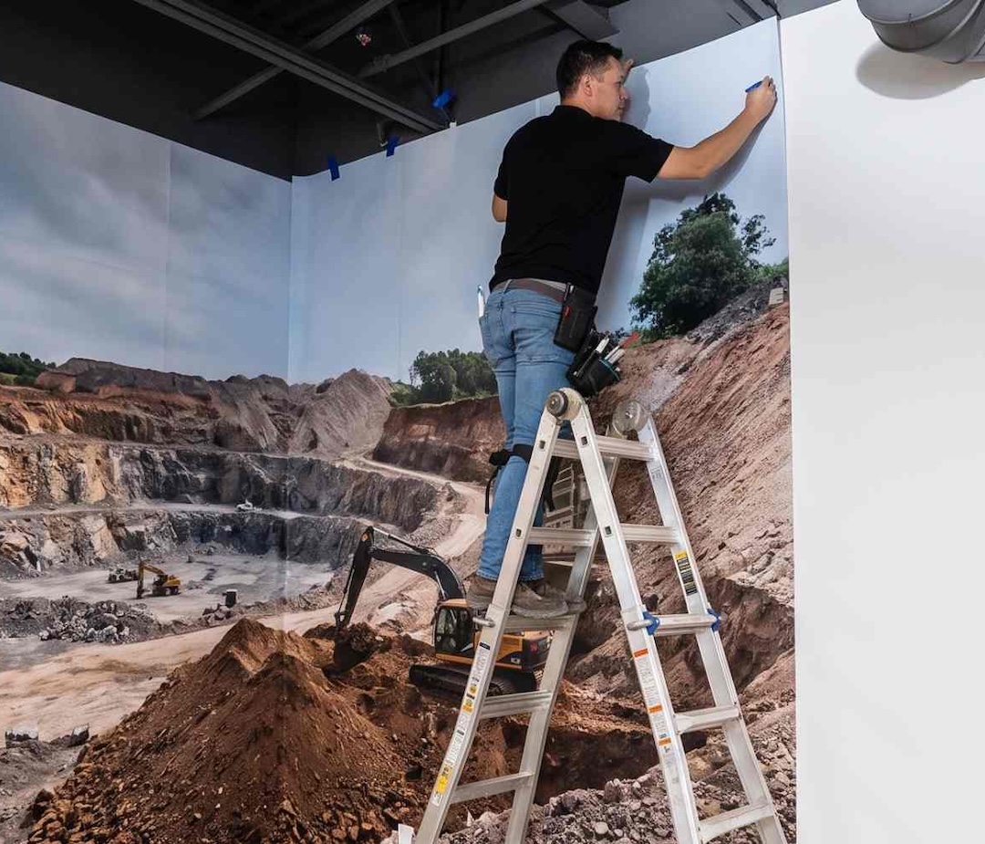 Brand Ink installer applying large-format wall graphics for a commercial interior project in the Minneapolis–St. Paul area.